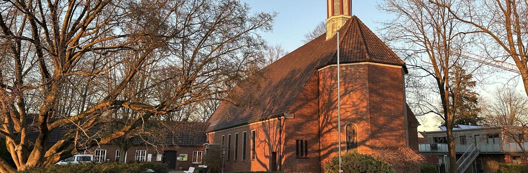 Header Christuskirche Oldenburg im Abendlicht von der Straße aus gesehen