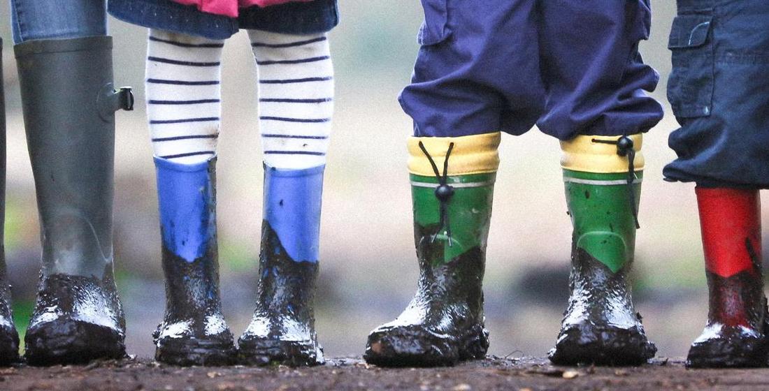 Header Angebote für Kinder Kinderbeine in schlammigen Gummistiefeln
