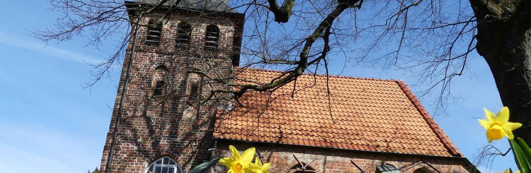 Header St. Gertruden-Kapelle Oldenburg von außen mit Narzissen